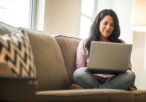 woman on couch on her laptop